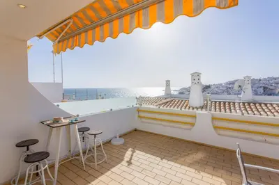 a balcony with stools and a view of the ocean at Old Town Beach Apartments in Albufeira