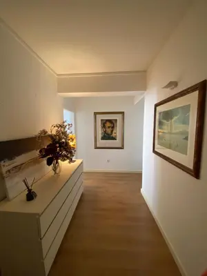 a hallway with a white room with a painting on the wall at Cosy Avenida Apartment in Faro