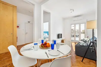 a white dining room with a white table and chairs at RG Sunny Ap in Faro