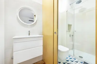 a bathroom with a toilet and a sink and a mirror at RG Sunny Ap in Faro