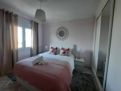a white bedroom with a bed and a mirror at Casa Oceano 1Bedroom apartment W/sea view in Quarteira