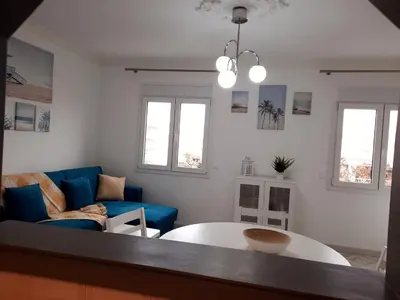 a living room with a table and a blue couch at Casa Oceano 1Bedroom apartment W/sea view in Quarteira