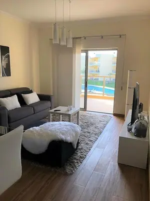a living room with a couch and a tv at MARINA BLEU Magnifique Appartement Standing vue Piscine in Albufeira