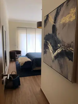 a bedroom with a bed and a painting on the wall at MARINA BLEU Magnifique Appartement Standing vue Piscine in Albufeira