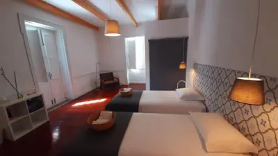 a hotel room with two beds and a television at A Casa do Tenente in Faro