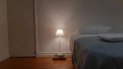 a bedroom with a bed and a lamp on the floor at A Casa do Tenente in Faro