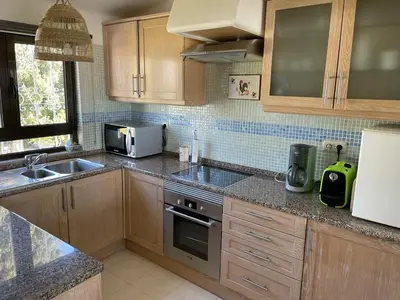 a kitchen with a sink and a stove top oven at Vue mer et piscine à 5 min à pied de Praia Sao Rafael Albufeira in Albufeira