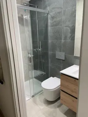 a bathroom with a shower and a toilet and a sink at Vue mer et piscine à 5 min à pied de Praia Sao Rafael Albufeira in Albufeira
