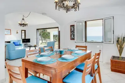 a dining room and living room with a table and chairs at Villa Brigida in Patroves
