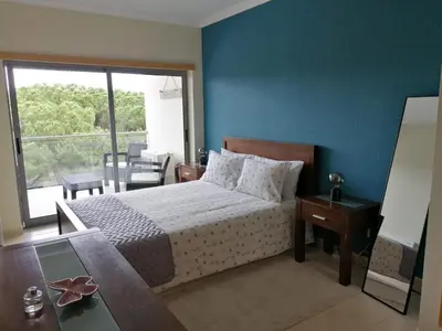 a bedroom with a bed and a blue wall at Casa Jacqueline in Albufeira