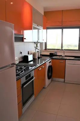 a kitchen with orange cabinets and a stove top oven at Casa Jaffa in Albufeira