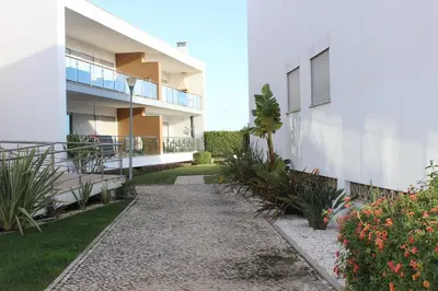 a walkway next to a white building with plants at Casa Jaffa in Albufeira