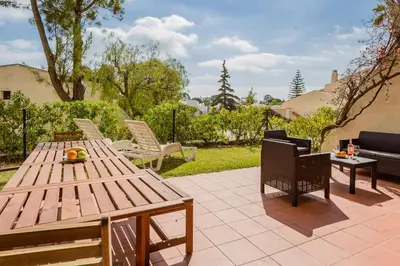 a patio with a wooden table and chairs at Gorgeous 2BDR Apartment W/Patio & Pool by LovelyStay in Vilamoura