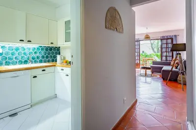 a kitchen with white cabinets and a living room at Gorgeous 2BDR Apartment W/Patio & Pool by LovelyStay in Vilamoura