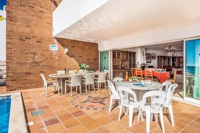a dining room with tables and chairs and a pool at Villa Oceano in Patroves