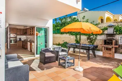 a patio with a ping pong table and an umbrella at Villa Oceano in Patroves