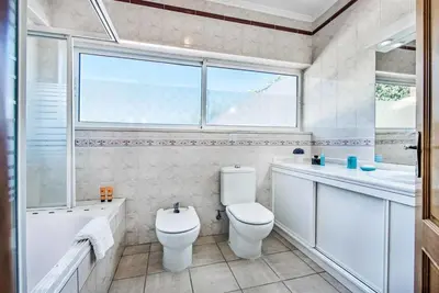 a bathroom with a toilet and a sink and a window at Villa Oceano in Patroves