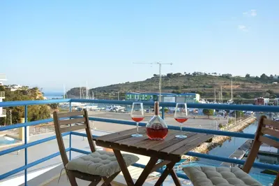 two glasses of wine sitting on a wooden table on a balcony at Wonderful Apartment Albufeira Marina 4B 2B in Albufeira
