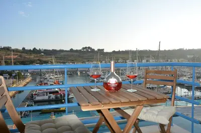 a wooden table with two glasses of wine on a balcony at Wonderful Apartment Albufeira Marina 4B 2B in Albufeira