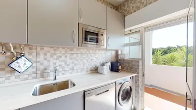 a kitchen with a sink and a washing machine at Apartamento Tranquilo T1 Albufeira 002 in Albufeira