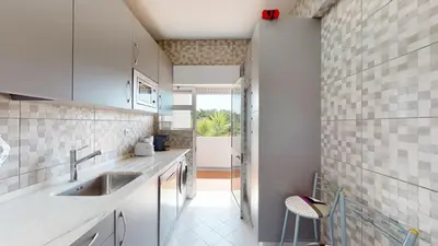 a kitchen with white cabinets and a sink at Apartamento Tranquilo T1 Albufeira 002 in Albufeira