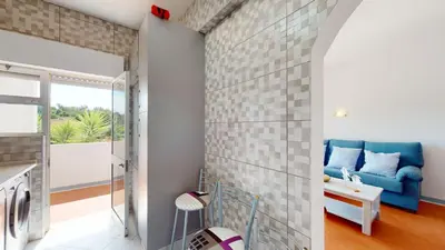 a living room with a blue couch and a balcony at Apartamento Tranquilo T1 Albufeira 002 in Albufeira
