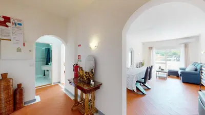 a living room with a table and a blue couch at Apartamento Tranquilo T1 Albufeira 002 in Albufeira