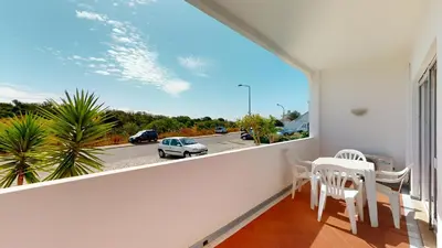 a balcony with a table and chairs and a view of a street at Apartamento Tranquilo T1 Albufeira 002 in Albufeira