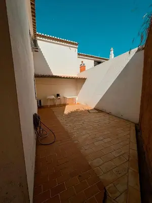 an empty courtyard of a house with a white wall at T2 sobre a praia - Albufeira/Olhos de Água in Albufeira