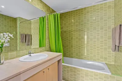 a green tiled bathroom with a sink and a tub at Corcovada Albufeira 1 Quarto by Glenge Holiday in Albufeira