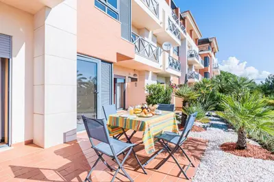 a patio with a table and chairs in front of a building at Corcovada Albufeira 1 Quarto by Glenge Holiday in Albufeira