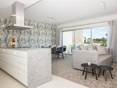 a kitchen and living room with a couch and a table at Green 2 Apartment by Stay ici Algarve Holiday Rental in Albufeira