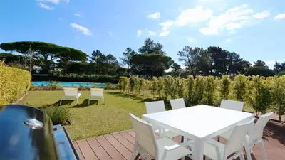 a white table and chairs on a patio with a garden at Vila Leonor - Clever Details , Central Vilamoura, Sleeps 6, luxury, walking distance in Vilamoura