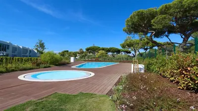a patio with two pools and a wooden deck at Vila Leonor - Clever Details , Central Vilamoura, Sleeps 6, luxury, walking distance in Vilamoura