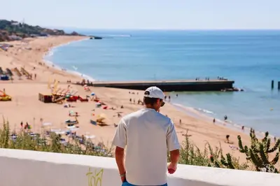 a man standing on a wall looking at a beach at Old Fisherman's Corner 16 - Centro Old Town Albufeira in Albufeira