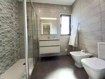 a bathroom with a toilet and a sink and a shower at T3 Alto Forte -Vista Mar,Ar Condicionado,Garagem in Quarteira
