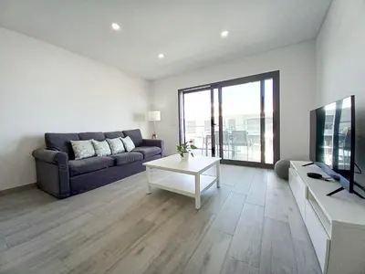 a living room with a couch and a tv at T3 Alto Forte -Vista Mar,Ar Condicionado,Garagem in Quarteira