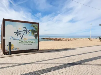 a sign on a beach with the ocean in the background at T3 Alto Forte -Vista Mar,Ar Condicionado,Garagem in Quarteira