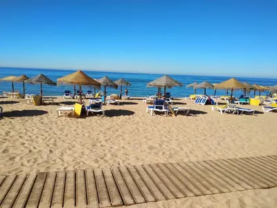 a beach with chairs and umbrellas and the ocean at T1 BOAVISTA 6 VISTA MAR Wi-Fi Ar Cond in Quarteira