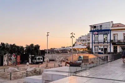 a group of people walking on a city street at Old Fisherman's Corner 5 - Centro Old Town Albufeira in Albufeira