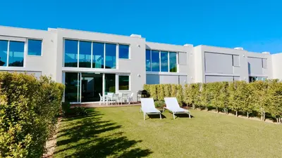 a white house with chairs in the yard at Villa Emilia - Clever Details , Central Vilamoura, Sleeps 6, luxury, walking distance in Vilamoura