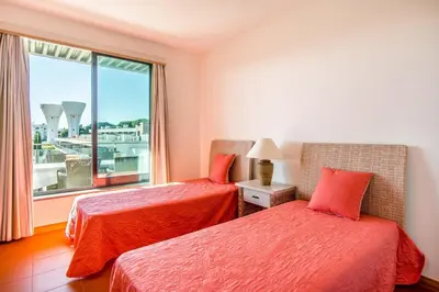a living room with a couch and a television at Superbe appartement spacieux avec terrasse vue piscine in Vilamoura