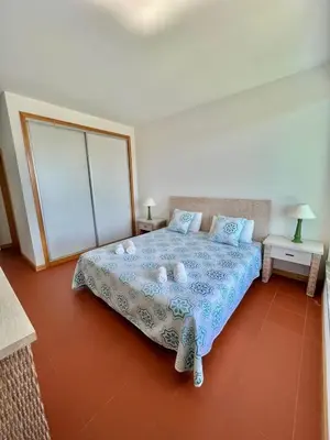 a kitchen with white cabinets and a stainless steel refrigerator at Superbe appartement spacieux avec terrasse vue piscine in Vilamoura