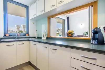 a kitchen with white cabinets and a window at Appartement Luxueux dans un site Exceptionnelle Vilamoura in Vilamoura