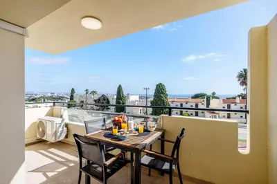 a bedroom with a bed and a view of the ocean at Appartement Chaleureux et Lumineux Proche Mer in Albufeira