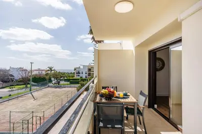 a living room with a couch and paintings on the wall at Appartement Chaleureux et Lumineux Proche Mer in Albufeira