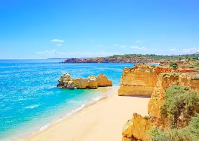 a beach with rocks in the water and the ocean at ALDEIA DAS AÇOTEIAS VILLAGEs in Albufeira