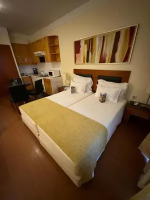 a hotel room with a large bed and a kitchen at Semanas 30 e 24 Vila Galé Cerro Alagoa in Albufeira
