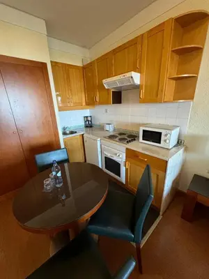 a kitchen with a table and a table and chairs at Semanas 30 e 24 Vila Galé Cerro Alagoa in Albufeira