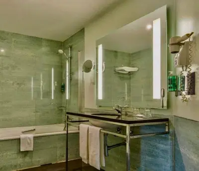 a bathroom with a sink and a tub and a mirror at Semanas 30 e 24 Vila Galé Cerro Alagoa in Albufeira